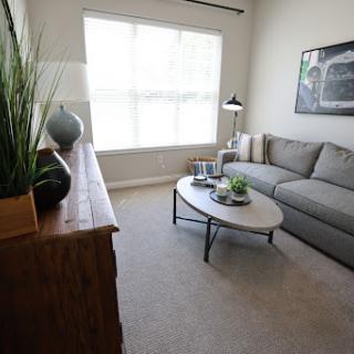 A cozy modern living room showcasing a comfortable sofa, stylish coffee table, and ample natural light.