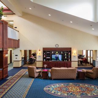 A spacious hotel lobby with comfortable seating and a large television.