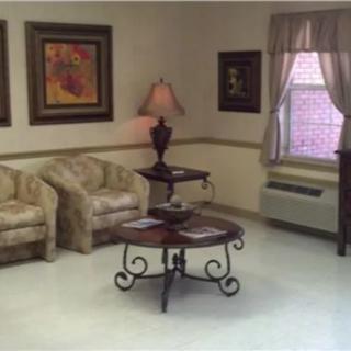 A cozy living room with armchairs, a coffee table, and decorative wall art.