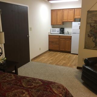 A cozy apartment with a small kitchenette and comfortable furnishings.