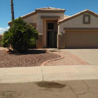 A suburban house with a large garage and desert landscaping.
