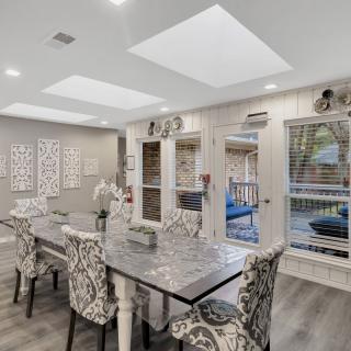 A stylish dining room with patterned chairs and abundant natural light.