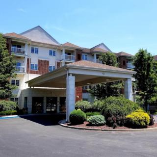 A residential apartment complex with a landscaped entrance and covered driveway.