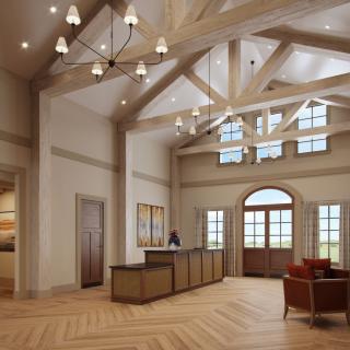A spacious and elegant reception area featuring high ceilings with wooden beams, abundant natural light, and a herringbone patterned floor.
