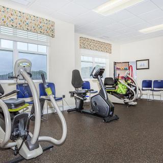 A gym room featuring various exercise equipment, including stationary bikes.