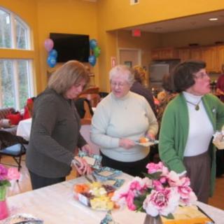 A group of women enjoying a social gathering in a brightly decorated room.