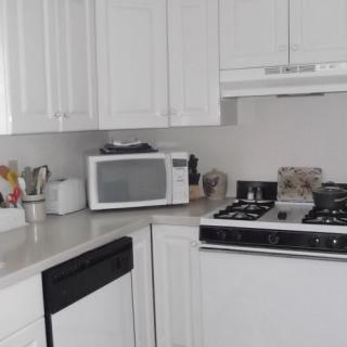 A modern kitchen with white cabinets and various appliances.