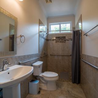 A well-lit bathroom featuring a sink, toilet, and shower area with modern fixtures.