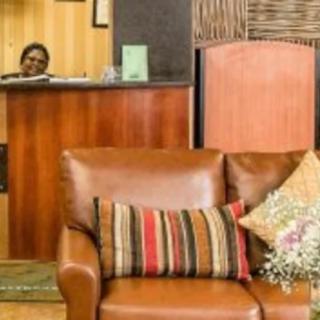 A cozy lobby area with a sofa adorned with colorful cushions and a reception desk in the background.