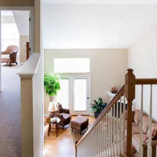 A bright and airy living room featuring a hardwood floor, comfortable seating, and natural light streaming through large windows.