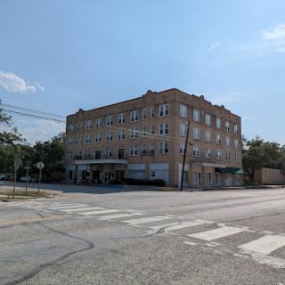 An urban building with a commercial storefront, captured on a clear day.