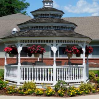 A picturesque gazebo surrounded by vibrant flowers in a garden setting.