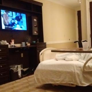 A view of a hospital patient room featuring a bed and television.