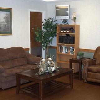 A cozy living room with a sofa, armchair, coffee table, and TV.