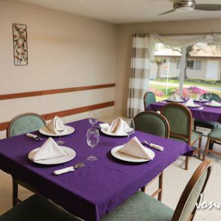 A cozy dining area arranged for a meal with elegant purple accents.