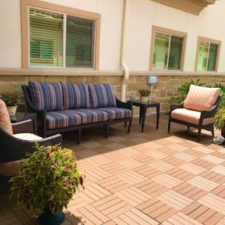 A cozy outdoor patio setup featuring comfortable seating and decorative plants.