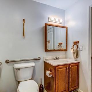 A small bathroom with a toilet, vanity, and mirror.