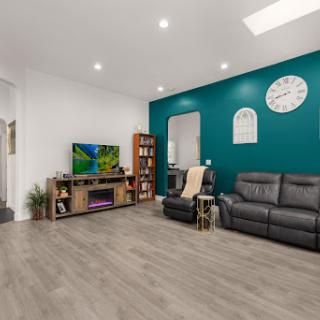 A cozy living room featuring a stylish teal accent wall and comfortable leather seating.