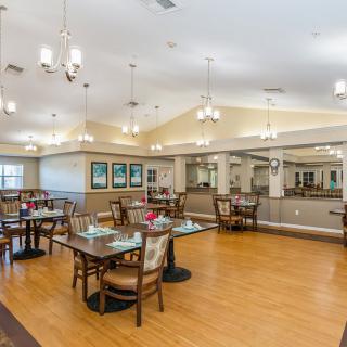 A spacious and well-lit dining area with neatly arranged tables and chairs.
