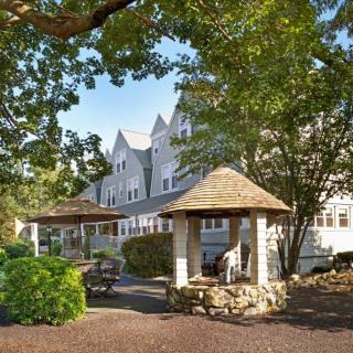 A charming building with a gazebo surrounded by lush greenery.