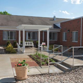 A charming residential building featuring an accessible entrance and a landscaped garden area.