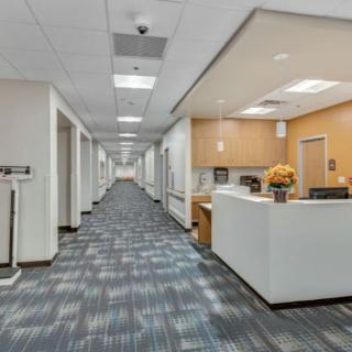 A modern office hallway with a reception desk and bright lighting.