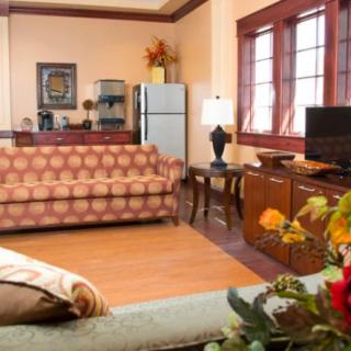 A cozy living room with a couch, fridge, and TV.