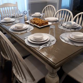 A dining table set for a meal with plates, glasses, and cutlery arranged neatly.