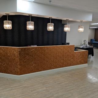 A stylish reception area featuring a wooden reception desk and modern pendant lighting.