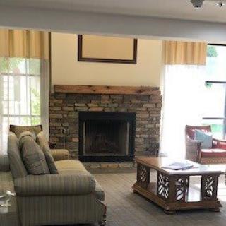 A cozy living room with a stone fireplace, comfortable sofa, and a wooden coffee table.