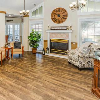A cozy living room with a fireplace, hardwood floors, and elegant furnishings.