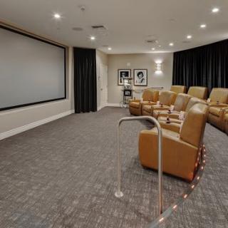 A modern home theater with comfortable seating and a large projection screen.
