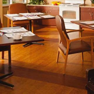A cozy dining area with wooden tables and chairs on a wooden floor.
