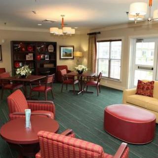 A cozy living room with red furniture and warm lighting.