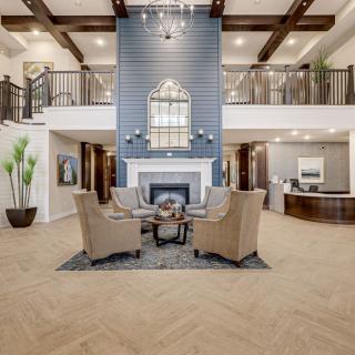 A modern lobby with a central fireplace and comfortable seating area.