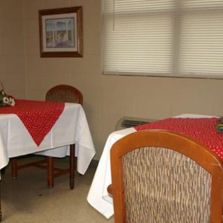 A cozy dining area with tables covered in red and white tablecloths.