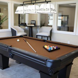 A modern game room featuring a pool table and comfortable seating.