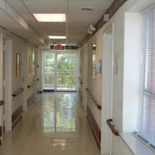 An empty hospital hallway with bright lighting and clean floors.