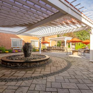 A serene outdoor patio featuring a central fountain and shaded seating areas, perfect for relaxation.