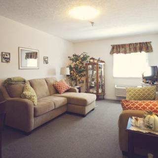 A cozy living room with a large sectional sofa and various decorative elements.
