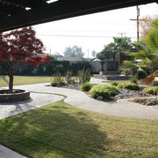 A serene garden space featuring well-maintained landscaping, a winding pathway, and vibrant plants.
