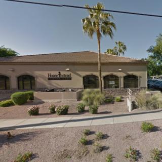 A commercial building featuring landscaping and palm trees.