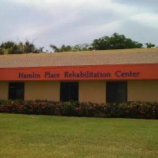 A rehabilitation center building with a well-maintained lawn in front.