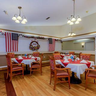 A decorated dining room with tables and chairs, adorned with American flags and festive decor.