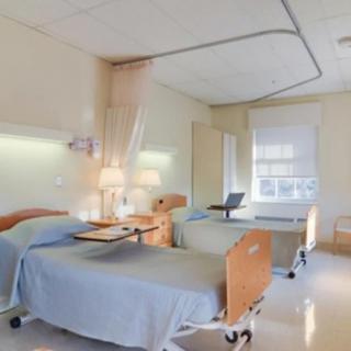 A clean and organized hospital room with two beds.