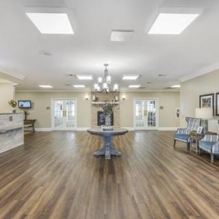 A bright and spacious interior lobby with a chandelier and hardwood flooring.