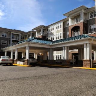 A modern residential building featuring a welcoming entrance and ample parking.