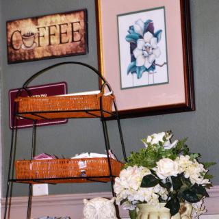 A cozy corner featuring a coffee-themed decor, wicker shelves, and floral arrangements.