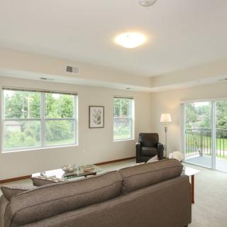 A modern and minimalist living room with large windows allowing natural light to fill the space.