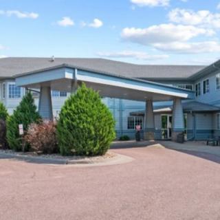 A hotel building with a covered entrance and landscaping.